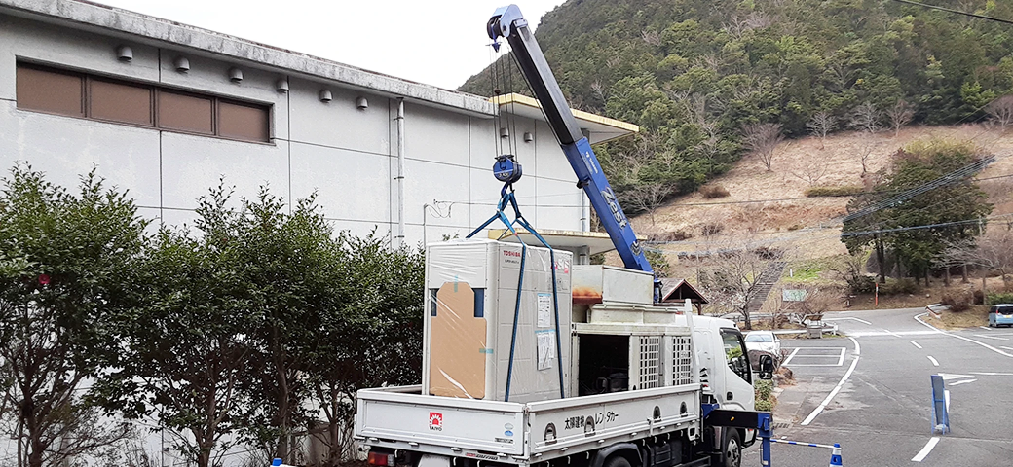 重機で運ばれる室外機