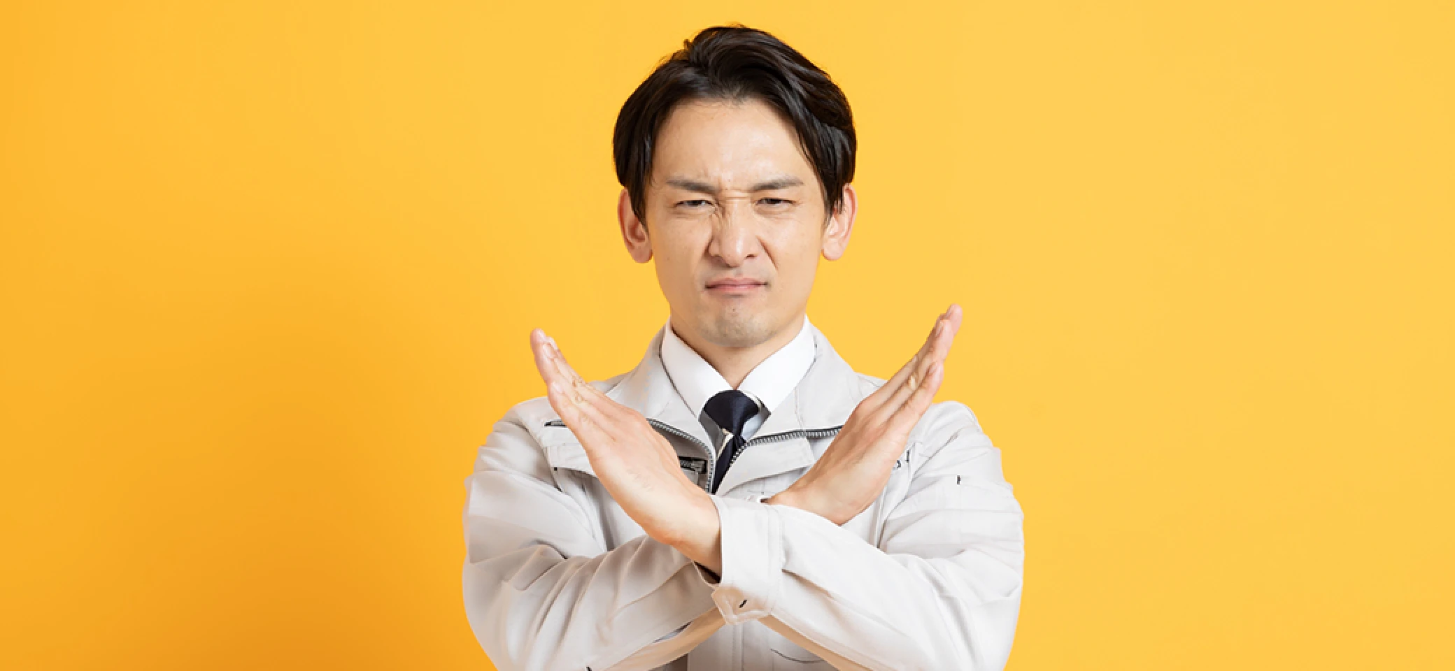 両手でバツを作る作業員